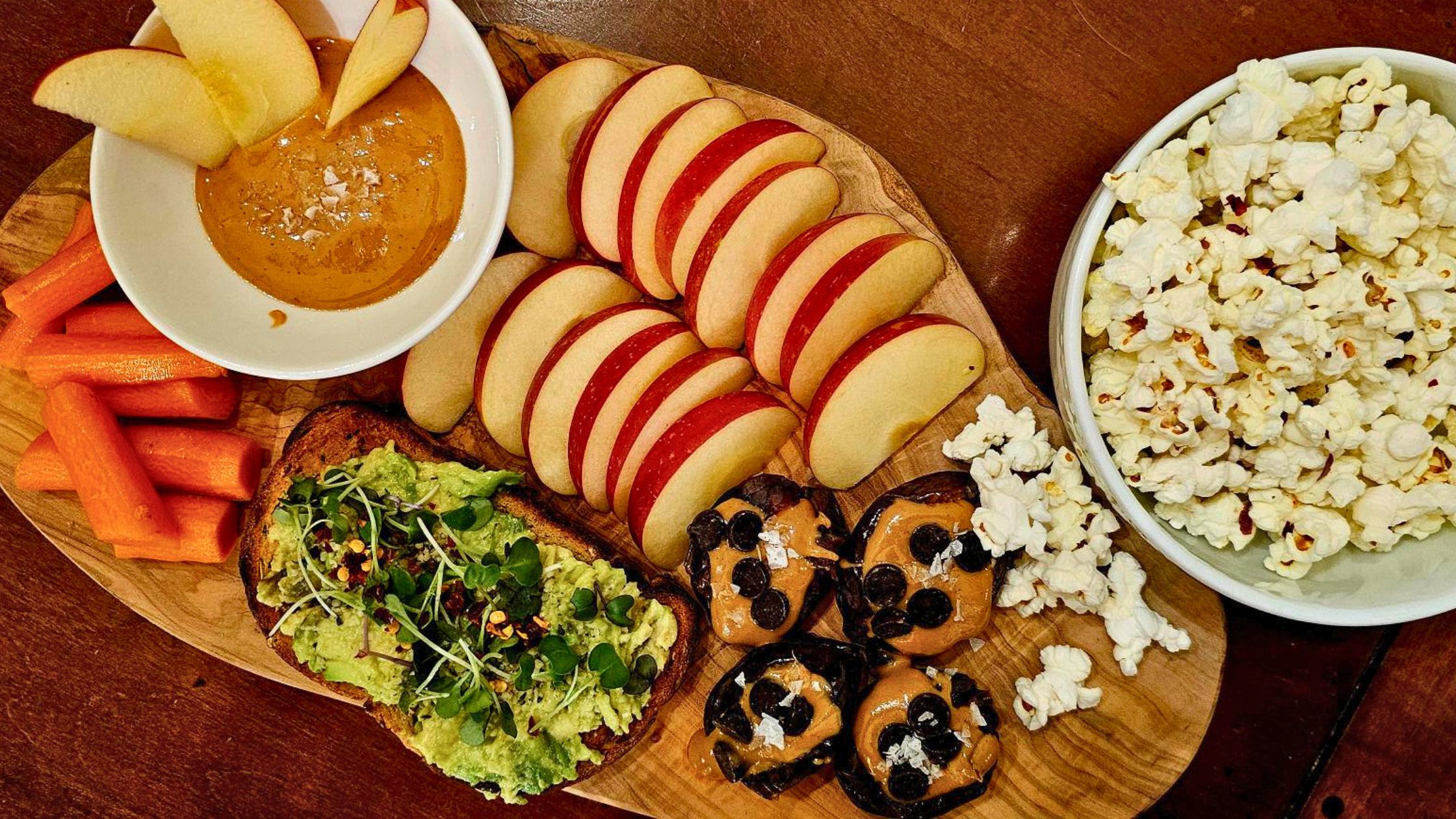 Healthy plant-based snacks apple, stuffed dates, avocado toast, popcorn