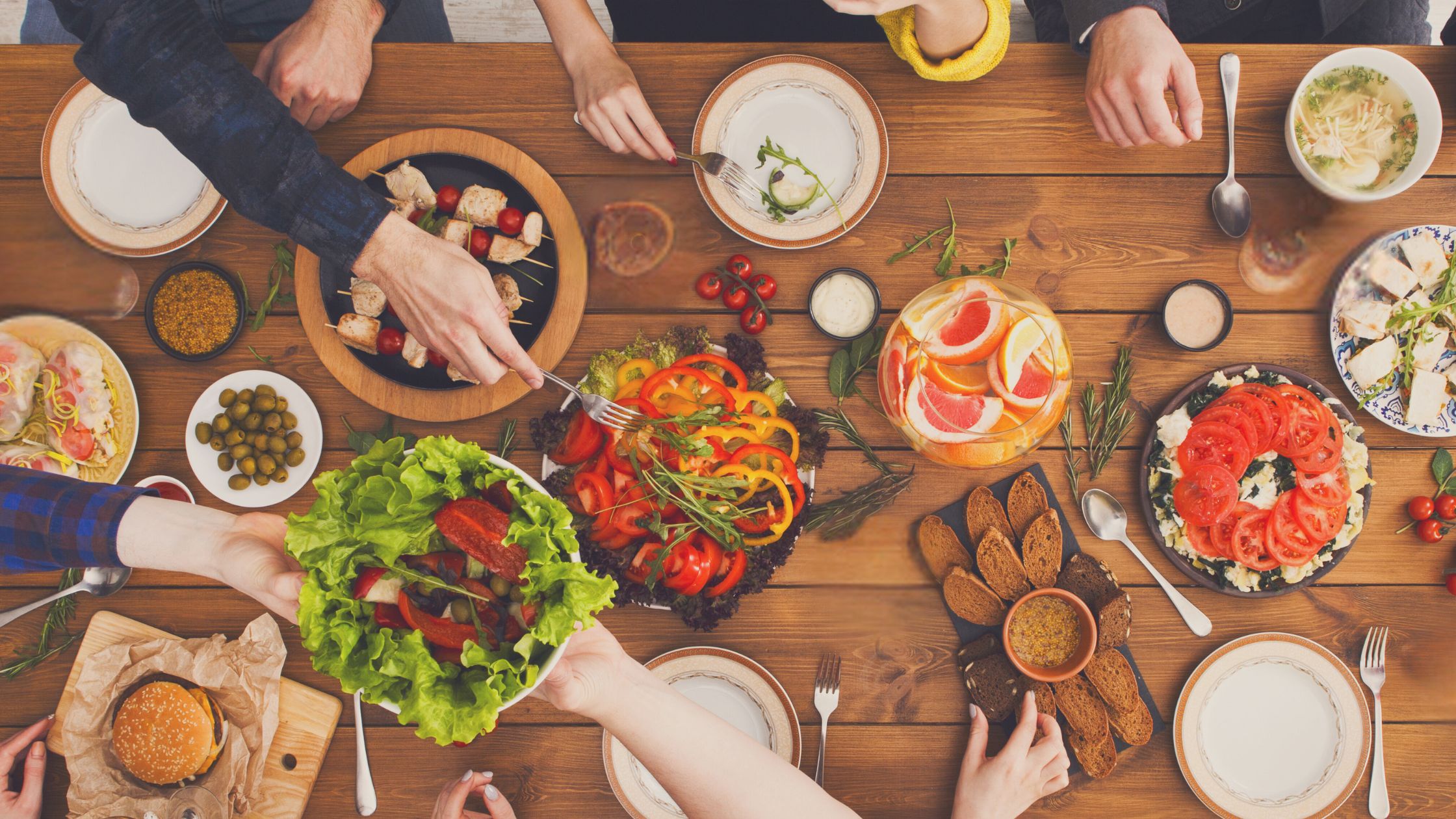 family eating plant-based and variety of healthy foods at dinner table